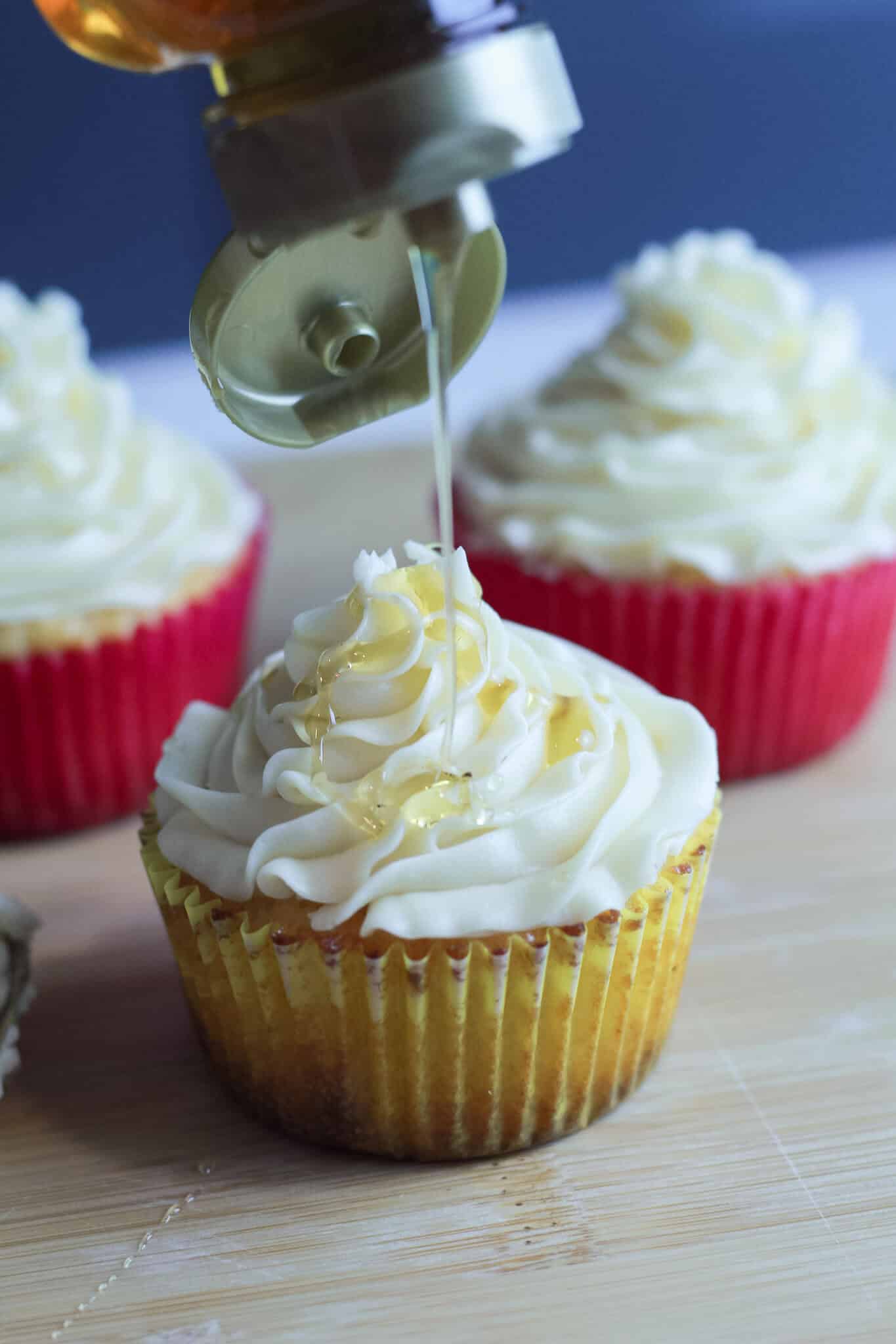 3 cupcakes with honey buttercream frosting and a honey drizzle.